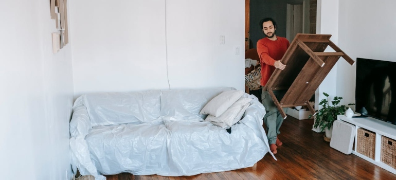 a man carrying a coffee table and wondering How much does an international move cost