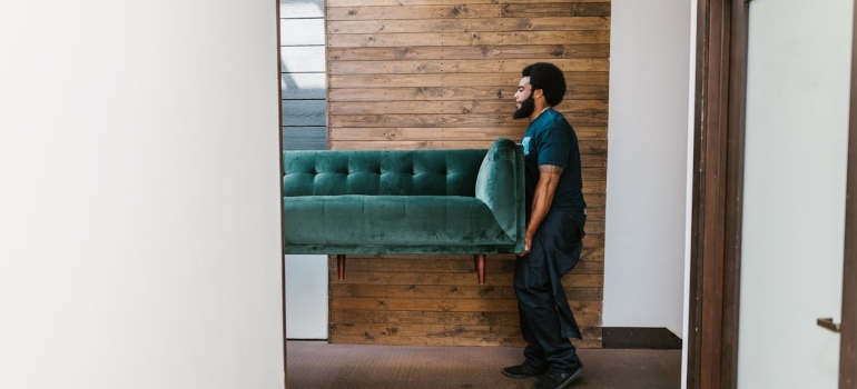 a man carrying a couch 