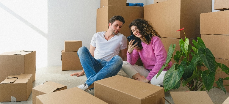 a couple surrounded by boxes moving to Canada from USA