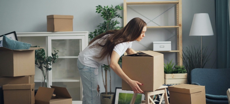 a woman lifting a box before moving to Canada from USA