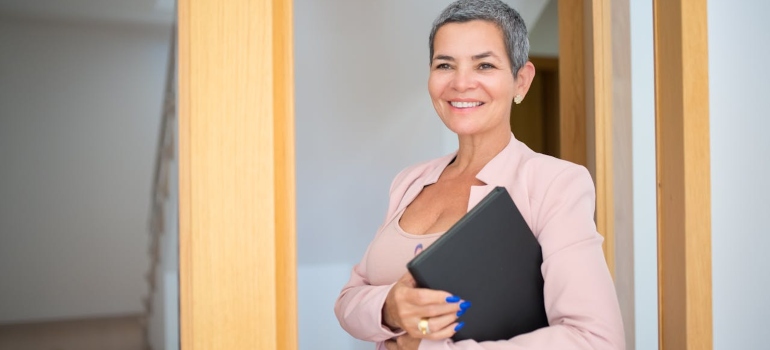 a woman smiling and holding some files 